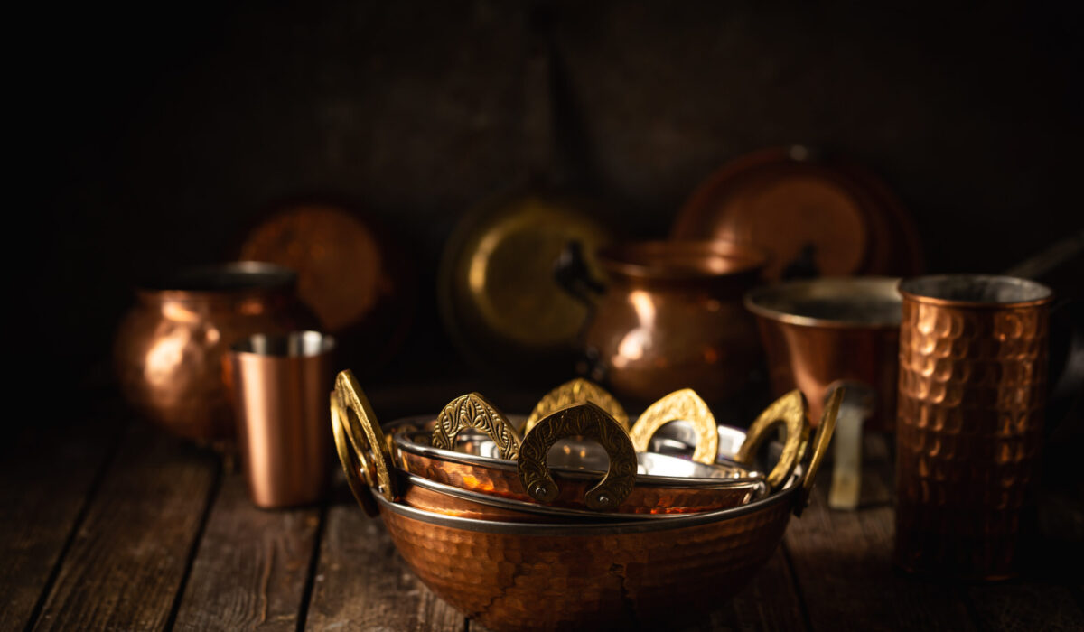 Vintage copper dishes, pots and pans on dark wooden background